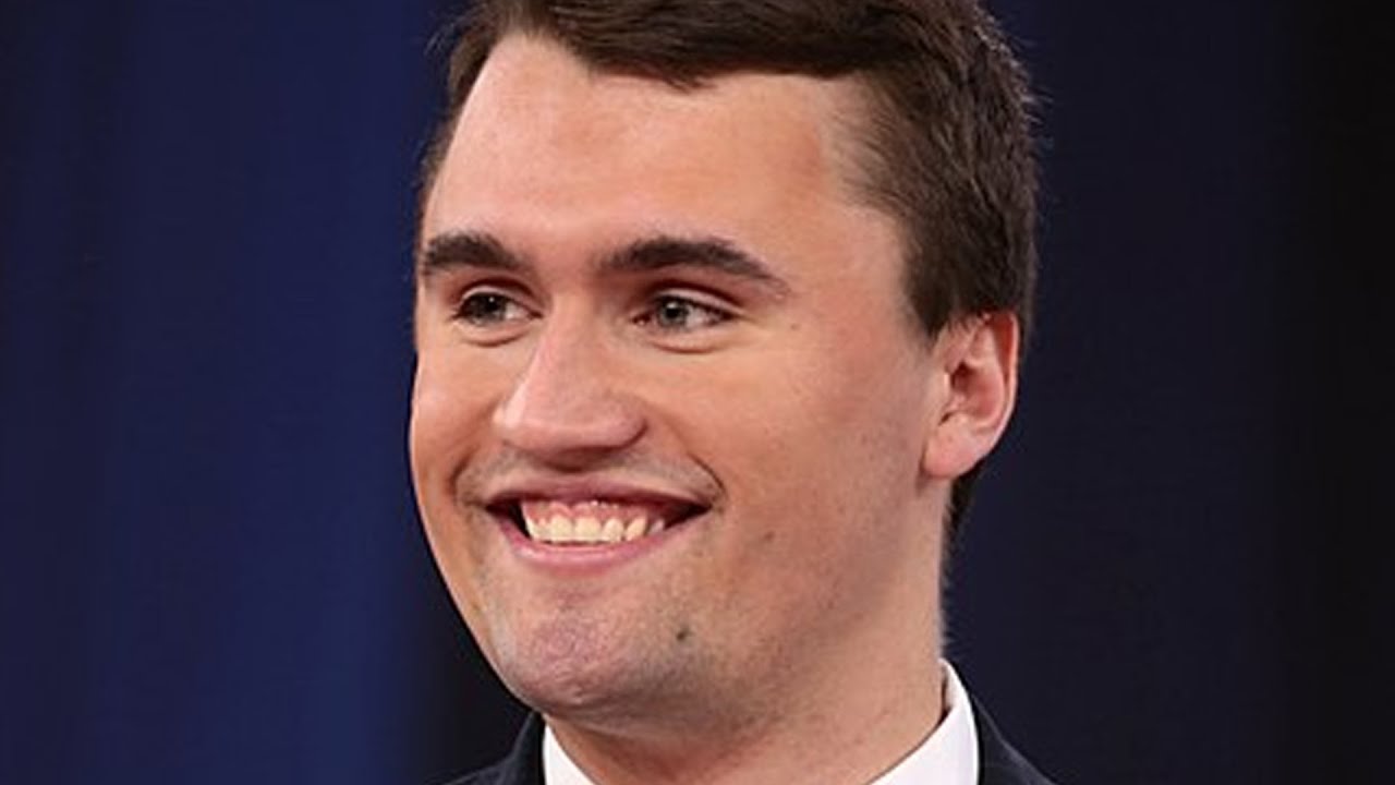 Close-up of Charlie Kirk smiling during a debate, showcasing symmetrical white teeth and dental aesthetics.